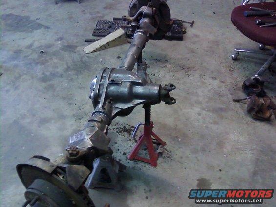 Vehicle axle assembly on jack stands in a garage