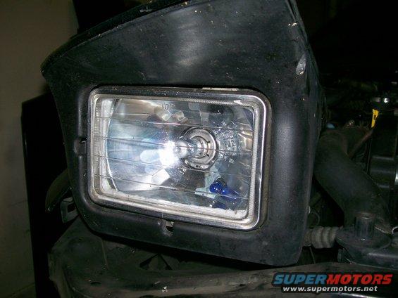 Headlight assembly with chrome trim and visible bulb