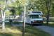 2005 Chevrolet Silverado 3500 - Motorhome parked at a campsite with picnic table and grill; other RVs visible in background.