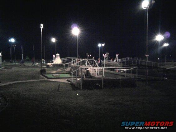 Mini golf course illuminated by lights at night