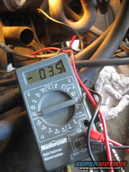 Mastercraft digital multimeter displaying -03.5 with red and black leads connected