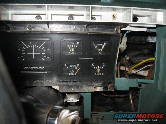Dashboard gauges for fuel, oil, temperature, and charge. 'UNLEADED FUEL ONLY' is printed below the fuel gauge