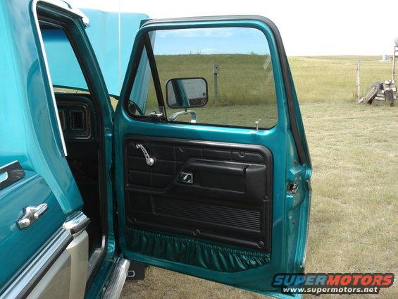 Teal 1979 Ford F-150 interior door panel with black trim and chrome handle