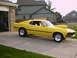 1969 Ford Mustang - 1969 Ford Mustang with a prominent hood scoop sits in a suburban driveway.