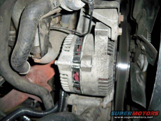 Close-up of an alternator and fan belt in an engine bay