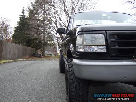 Front corner of a black 1995 Ford F-150 parked on a street