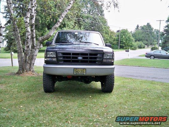 Black Ford F-150 truck, front view, parked on grass with trees and a mailbox. License plate SWZ-35L