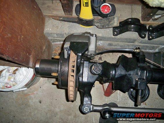 Front axle assembly with disc brake, caliper, and tie rod end. Some rust on brake rotor