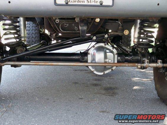 Rear axle assembly with shiny differential cover and suspension components, viewed from below