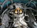 1995 GMC Sierra 1500 - The engine bay shows a carburetor and distributor, with various hoses and wires connected.