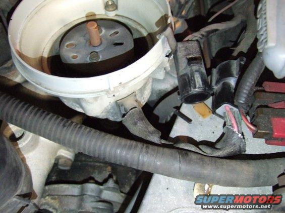 Engine distributor with wires and hoses. A Supermotors.net watermark is visible