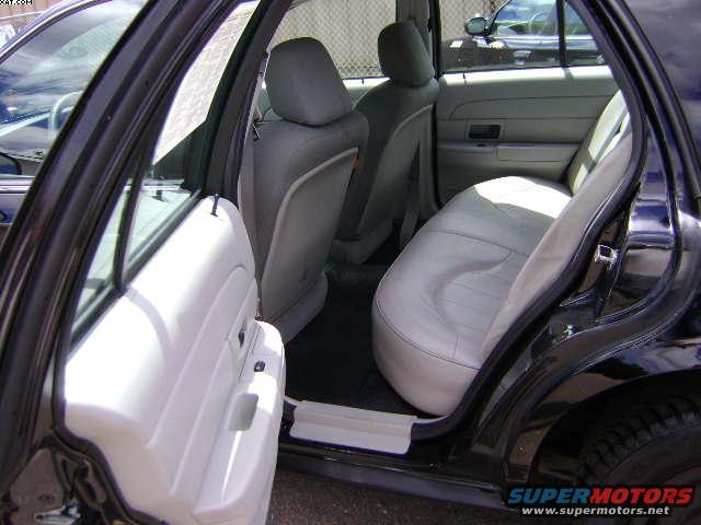 Interior of a black sedan showing light gray cloth seats and white door panel