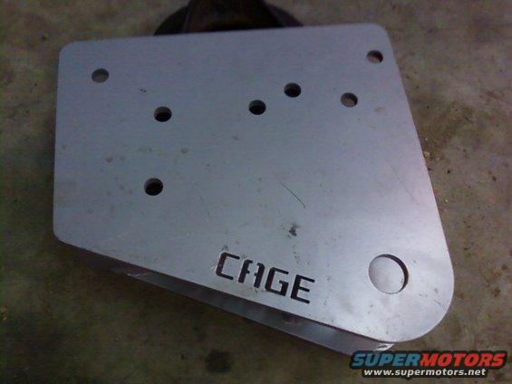 Metal plate with CAGE cut into it, has several bolt holes