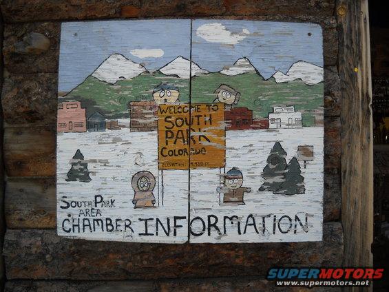 Hand-painted sign for South Park, Colorado, with cartoon characters and mountains
