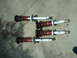 2003 Acura TL - Four aftermarket coilover suspension assemblies are displayed on a concrete surface, with visible branding on the shock bodies.