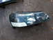 2003 Acura TL - Headlight assembly, likely for a sedan, shows signs of wear and has a piece of white tape applied to the lower corner.
