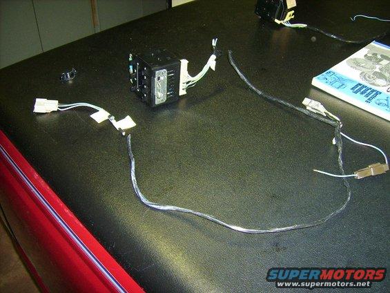Automotive electrical control module with wiring harness connectors on a black surface