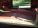 1964 Ford Fairlane - The interior floor of a vehicle is visible, showing the red primer and the shape of the floor pan.