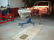 1964 Ford Fairlane - A car body is undergoing restoration with its engine removed and placed on a stand.