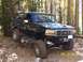 1994 Ford Bronco - This 1994 Ford Bronco navigates a challenging, rocky trail surrounded by trees.