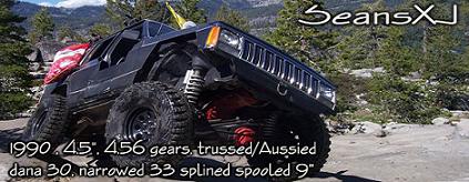 Black off-road SUV with large tires and lifted suspension, 1990 model