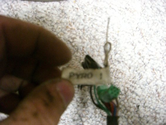 Hand holding a label that says PYRO 1, attached to some wires