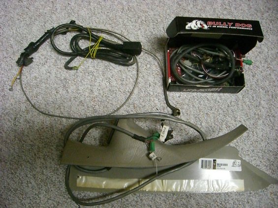 Bully Dog Outlook module box with wiring, and a tan plastic interior trim piece with cables