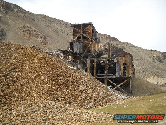 abandoned wooden mine building on a rocky hillside