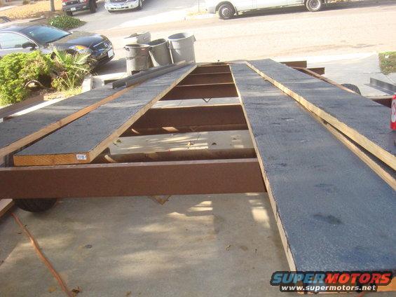 Trailer with wooden ramps and a tire visible