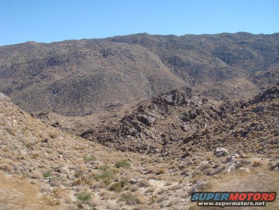 Desert mountains and dry brush under a clear blue sky