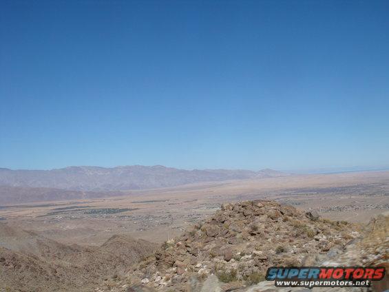 Desert landscape with mountains in the distance and a small town below