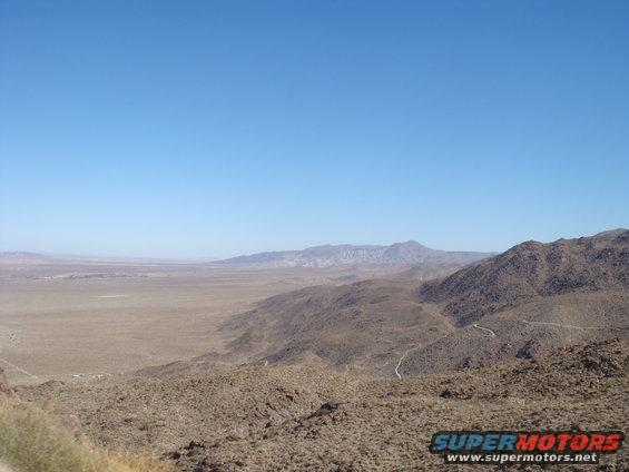 Wide shot of a dry, mountainous desert with a clear blue sky