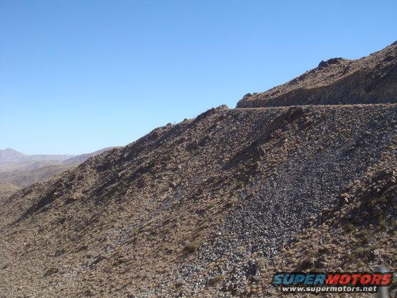 Mountain landscape with a road and Supermotors logo
