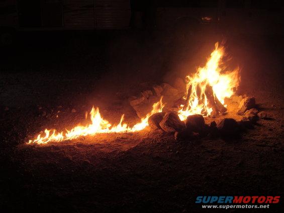 Campfire burning at night with rocks around it