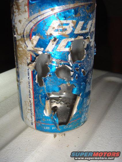 Damaged Bud Light can with holes and dirt