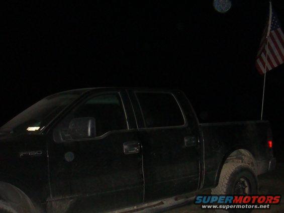 Black pickup truck side view with American flag