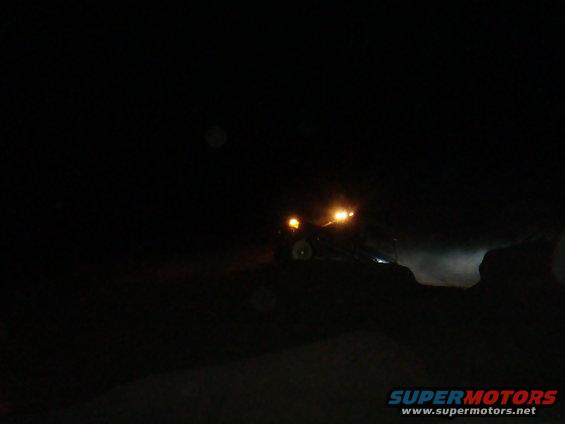 Off-road vehicle with headlights on driving at night