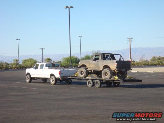 Lifted 1992 Ford Bronco on trailer, towed by white Ford F-Series truck