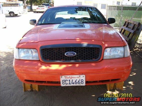 Orange Ford Crown Victoria, front view, with a hood scoop and California plates