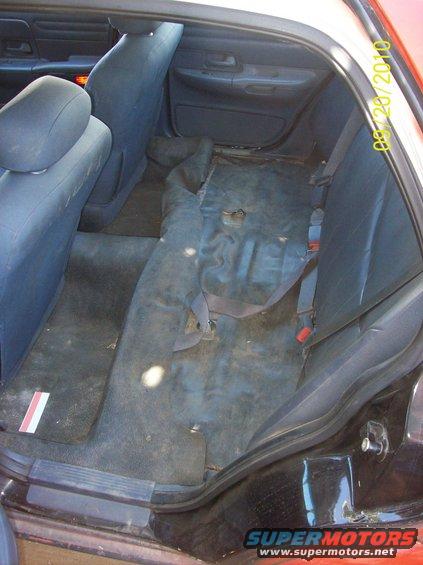 Interior of a 2002 Ford Crown Victoria showing blue cloth seats and dirty floor mats