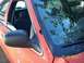2002 Ford Crown Victoria - The interior of an orange 2002 Ford Crown Victoria is visible, including the side mirror and a reflection of trees on the windshield.