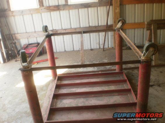 Red metal platform with wheels and metal frame
