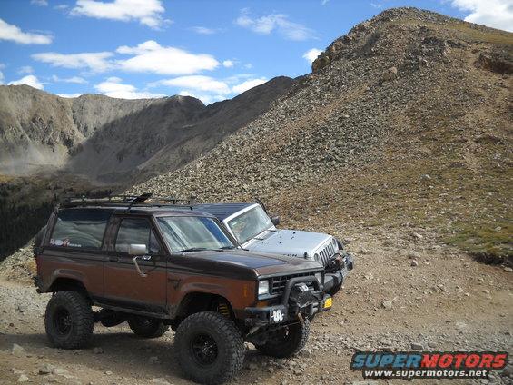 1986 Ford Bronco II and a Jeep parked on a rocky mountain trail