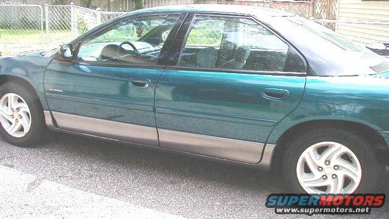 Side view of a teal sedan with a silver lower body trim. The interior is visible through the windows