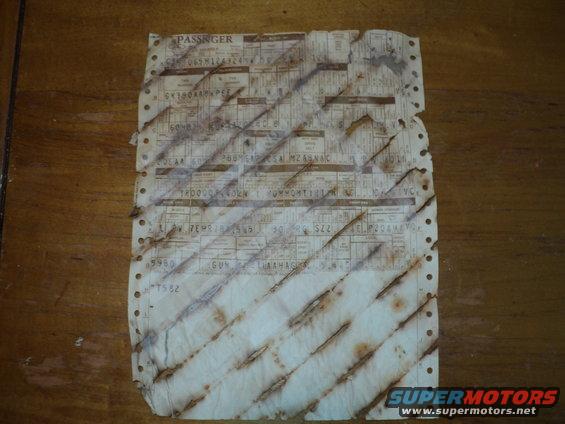 Tattered vehicle registration document with rows of data and punch holes