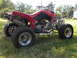 2004 Honda TRX 400 EX - A red ATV with aftermarket exhaust and chrome wheels is parked on a grassy lawn.