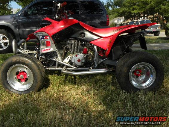 2004 Honda TRX 400 EX ATV parked on grass, side view. Honda logo visible on rear fender