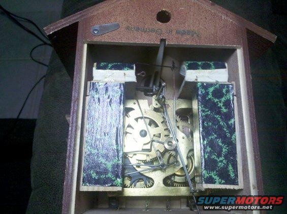 Cuckoo clock mechanism with brass gears and pendulum rod, "Made in Germany" text visible