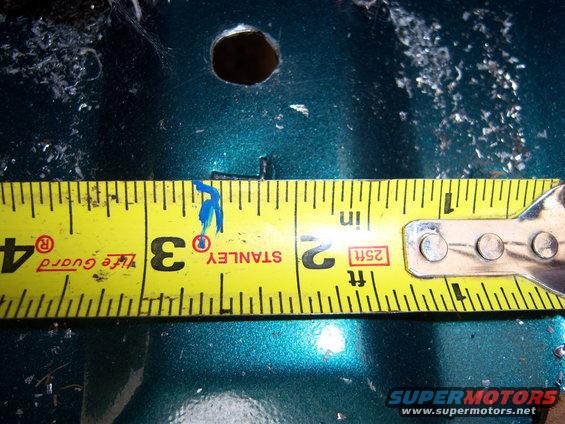Tape measure shows a hole is about 3.25 inches wide on a teal surface