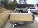1978 Ford Ranchero - Rear view of a yellow 1972 Ford Ranchero pickup truck with a dog in the bed, parked next to a white car.